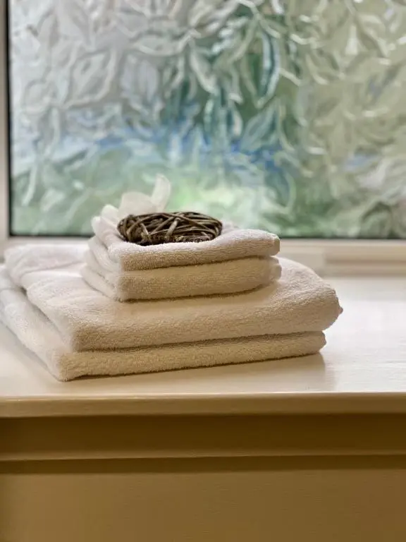a stack of towels sitting on a table with a candle at The Stags Head Apartment in Inverness