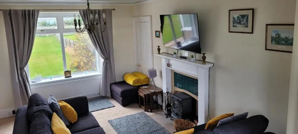a living room with a couch and a fireplace at The Mouries Holiday Cottage in Fochabers