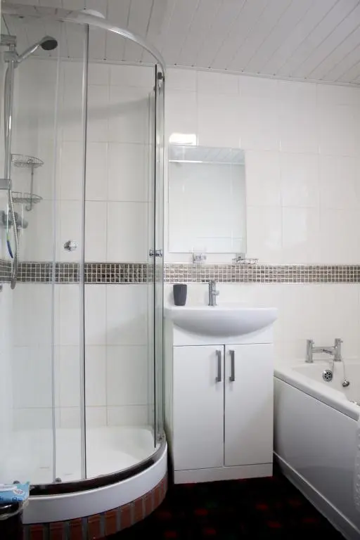 a bathroom with a shower and a sink and a tub at The Mouries Holiday Cottage in Fochabers