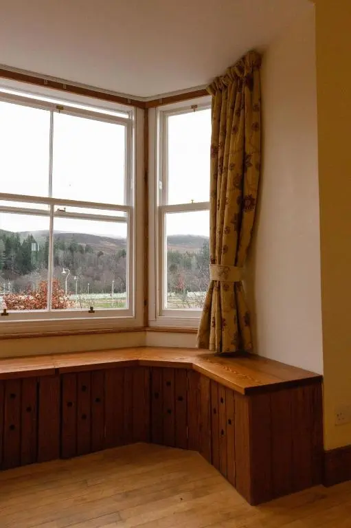 a window seat in a room with two windows at Schoolhouse in Ballater
