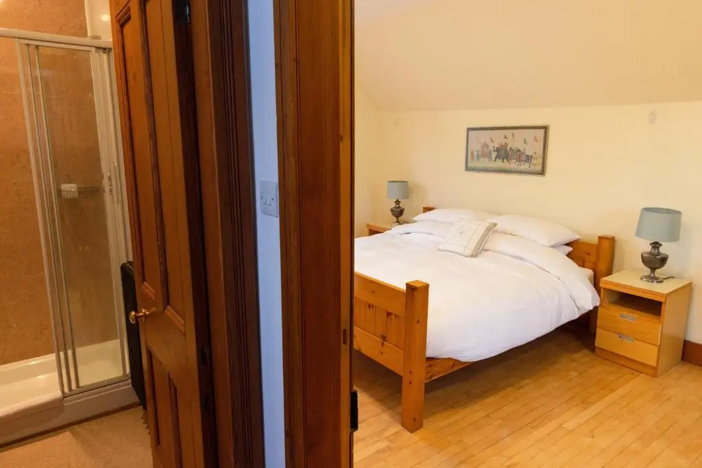 a bedroom with a bed and a glass door at Schoolhouse in Ballater