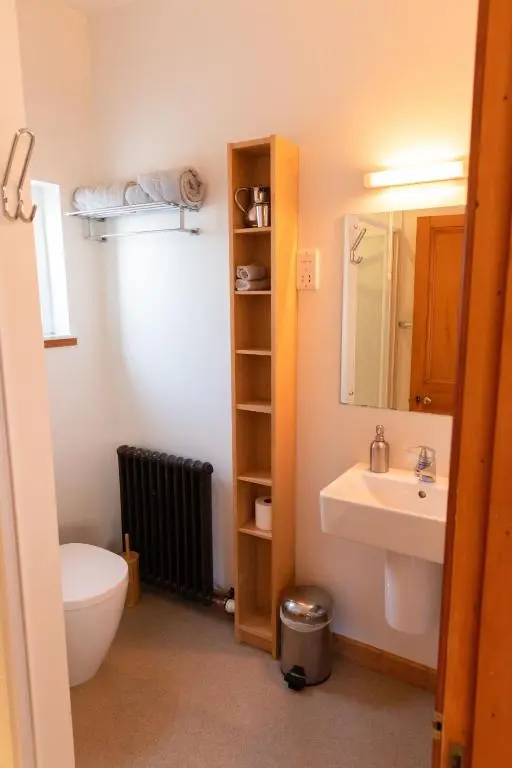a bathroom with a sink and a toilet and a mirror at Schoolhouse in Ballater