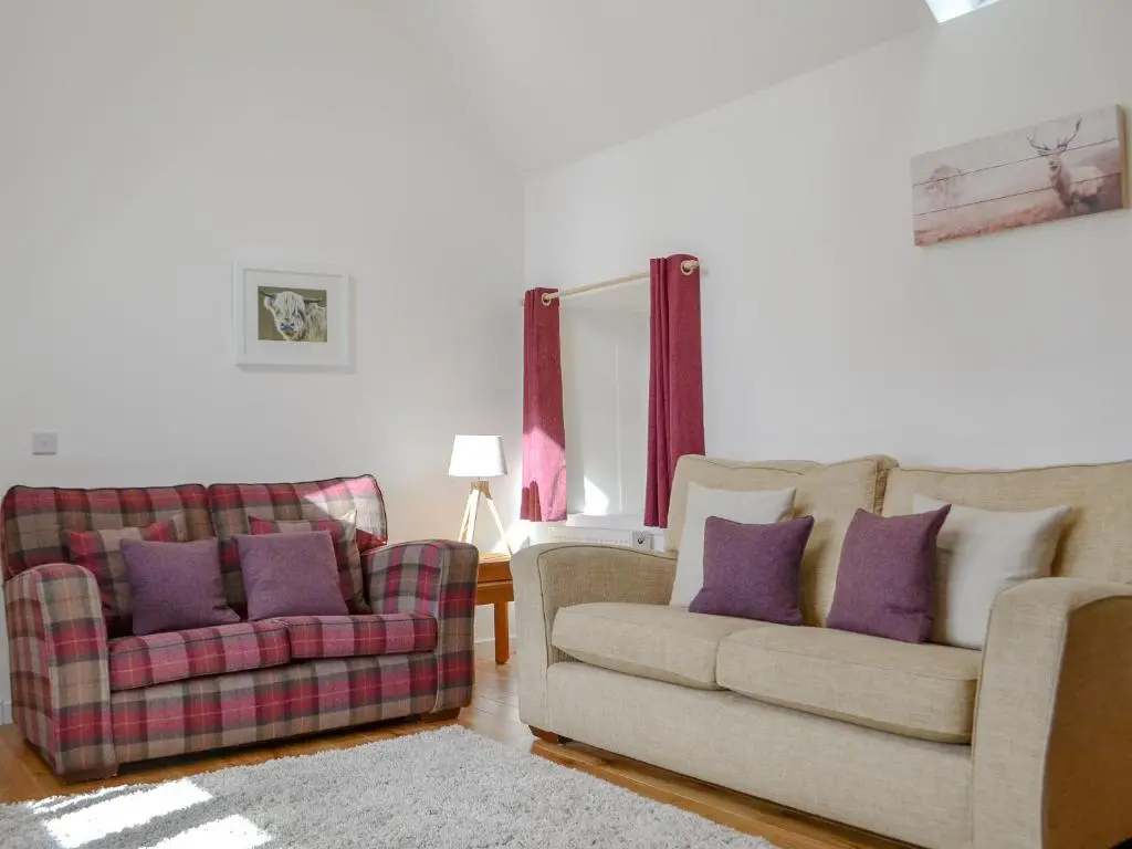 a living room with two couches and purple pillows at Wester Laggan Cottage in Skye of Curr