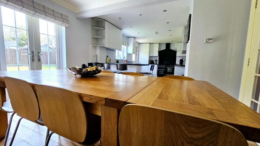 a large wooden table in a kitchen with chairs at 26 Woodgrove Drive in Inverness
