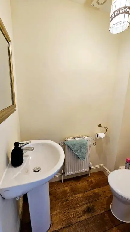 a bathroom with a white sink and a toilet at 26 Woodgrove Drive in Inverness