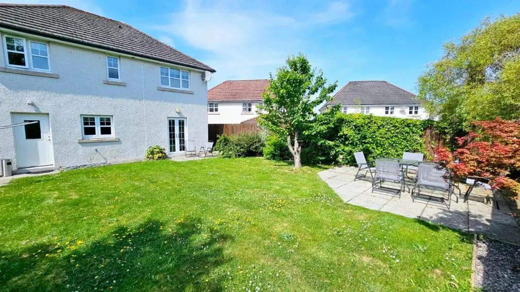 a backyard with chairs and a table in a yard at 26 Woodgrove Drive in Inverness