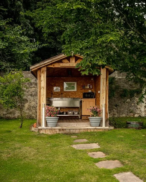 a wooden gazebo with a sink in a garden at Delny Glamping and Farm Animals in Invergordon