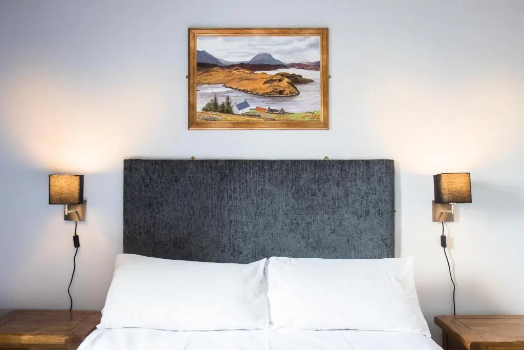 a bedroom with a bed with a picture above it at Bazpackers in Inverness