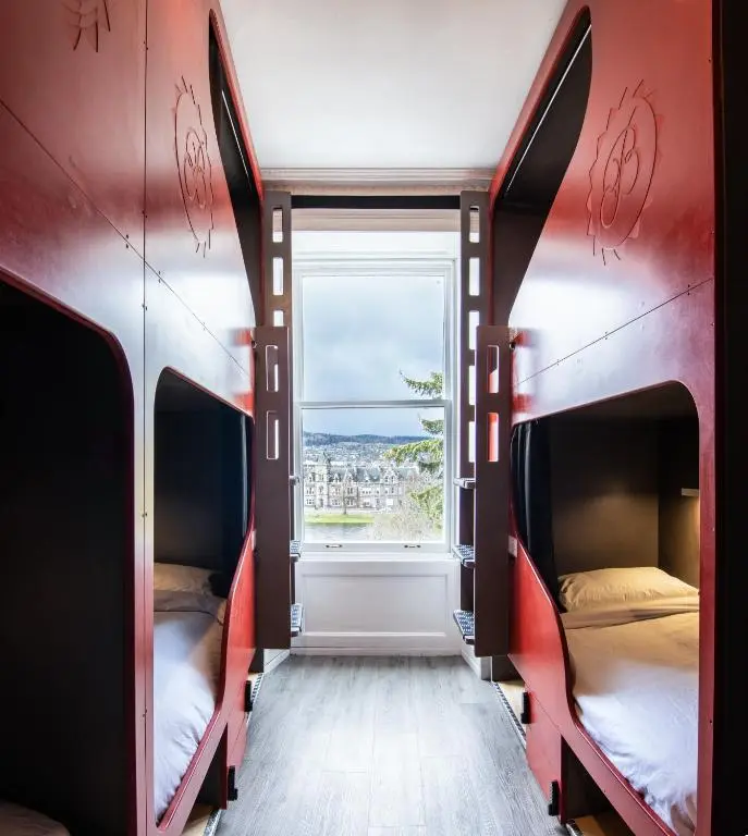two beds in a room with a window at Bazpackers in Inverness