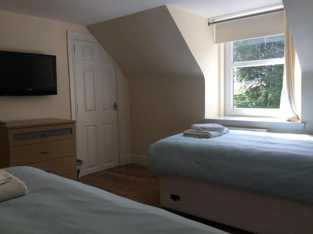 a bedroom with two beds and a window at Craig Cottage in Banff