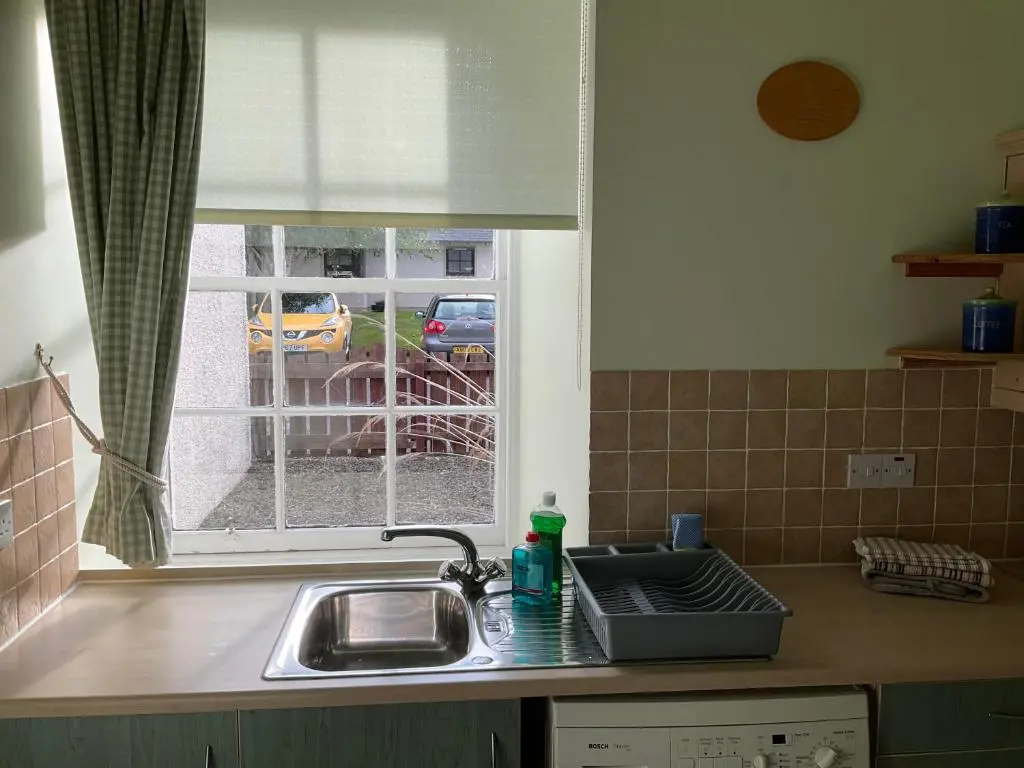 a kitchen counter with a sink and a window at Courtyard Cottage Free Parking in Inverness