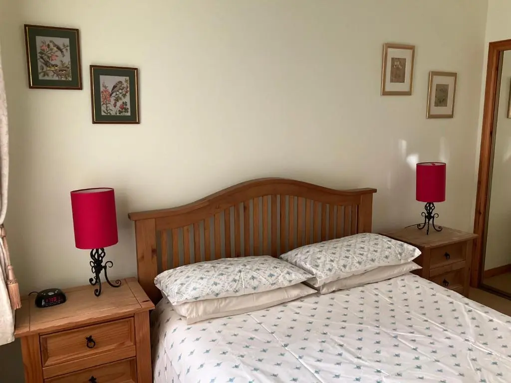 a bedroom with a bed with two lamps on night stands at Courtyard Cottage Free Parking in Inverness