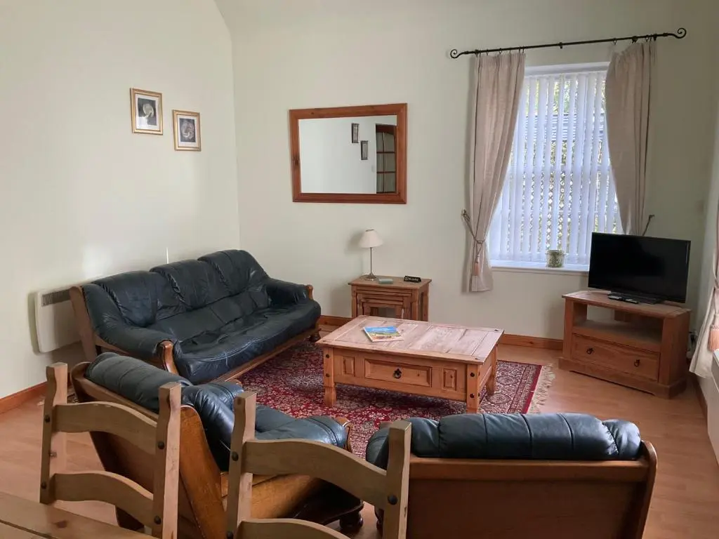 a living room with a couch and a table at Courtyard Cottage Free Parking in Inverness