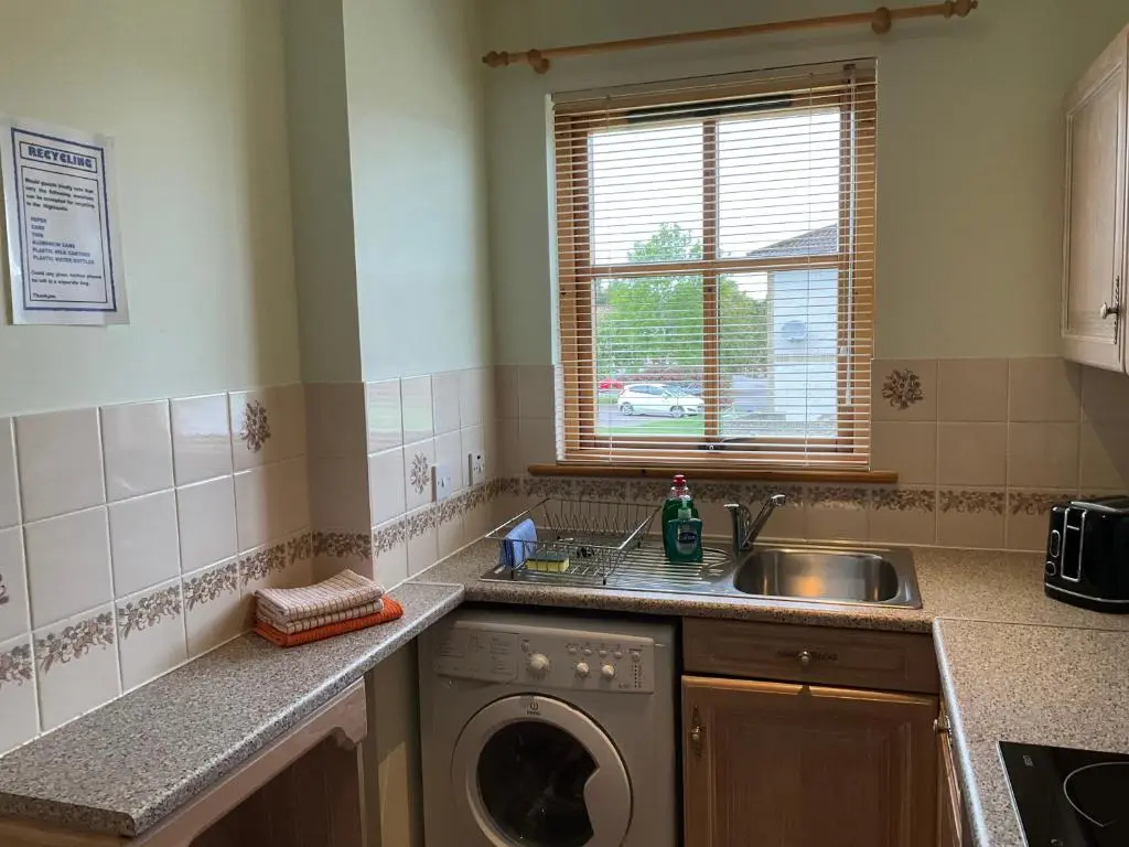 a kitchen with a sink and a washing machine at Two Bedroom Glen View Free Parking in Inverness