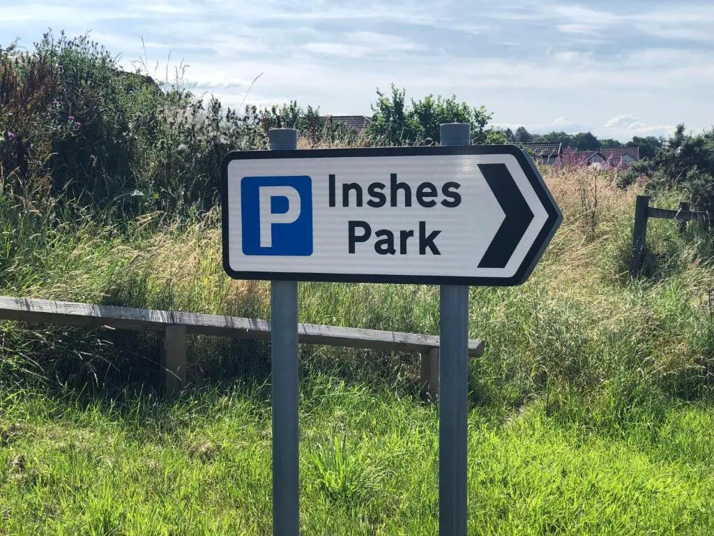 a sign for a parking lot in a field at Two Bedroom Glen View Free Parking in Inverness