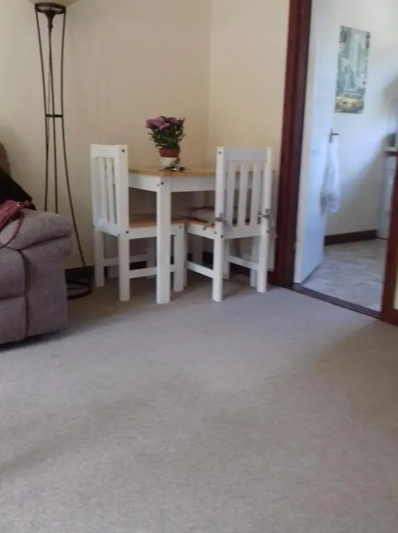 a room with a table and two white chairs at Culduthel Vista Apartment in Inverness