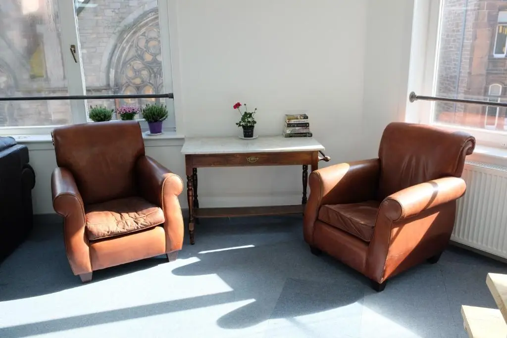 two chairs and a table in a room with windows at Black Isle Hostel in Inverness