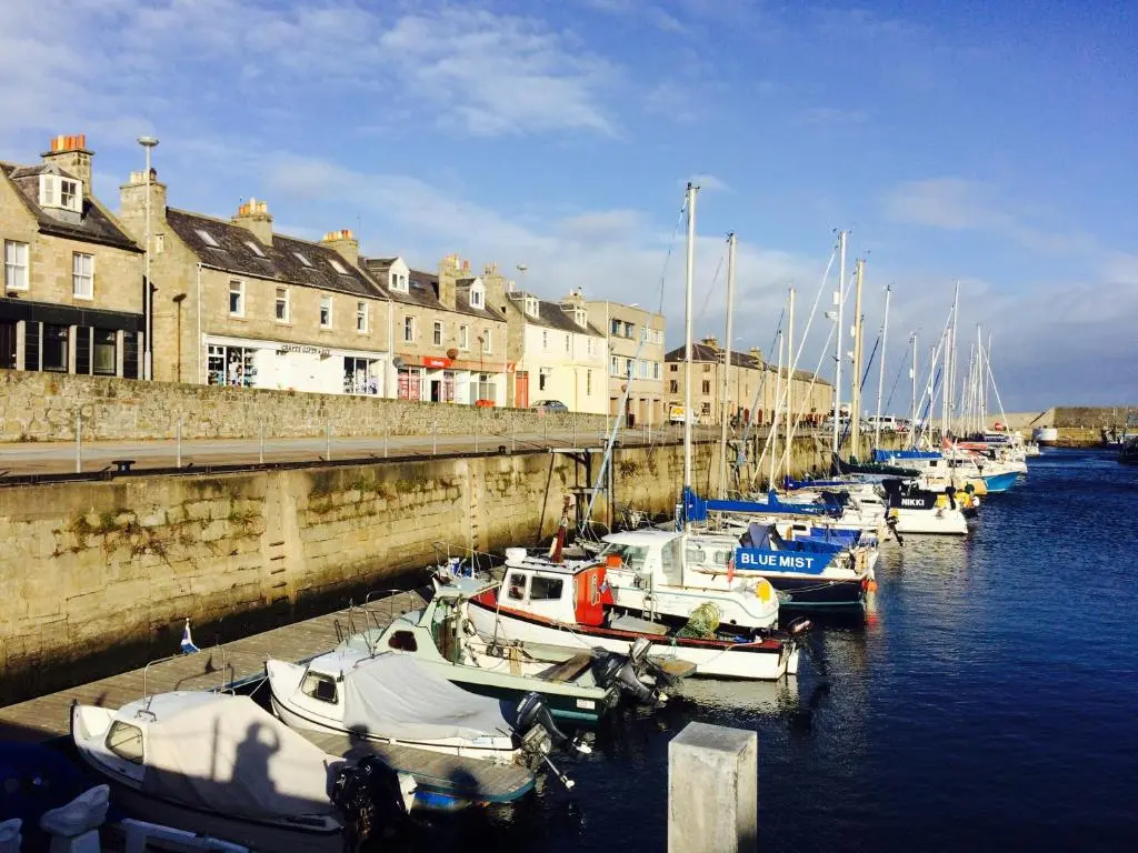 a group of boats docked in a harbor with buildings at 6 Seatown, Lossiemouth in Lossiemouth