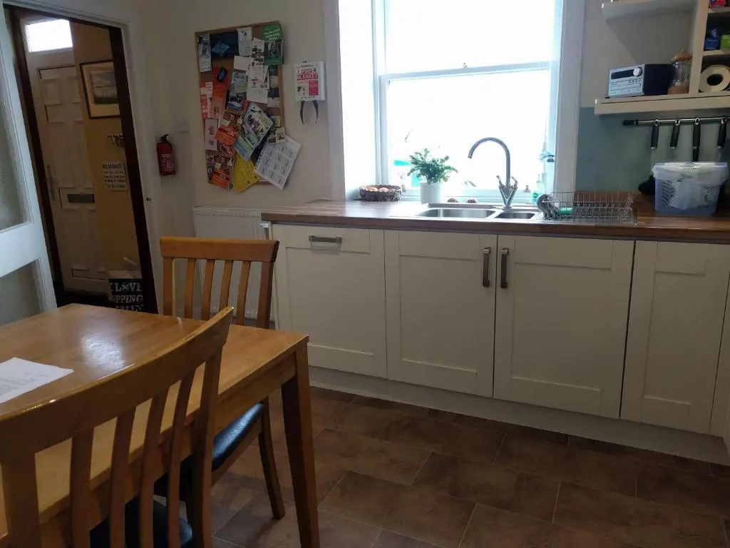 a kitchen with a sink and a table and a window at Sandend Cottage in Banff