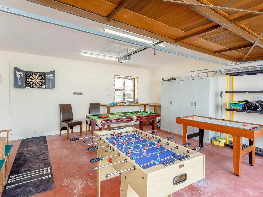 a room with two tables and pool tables at The Lookout in Aviemore