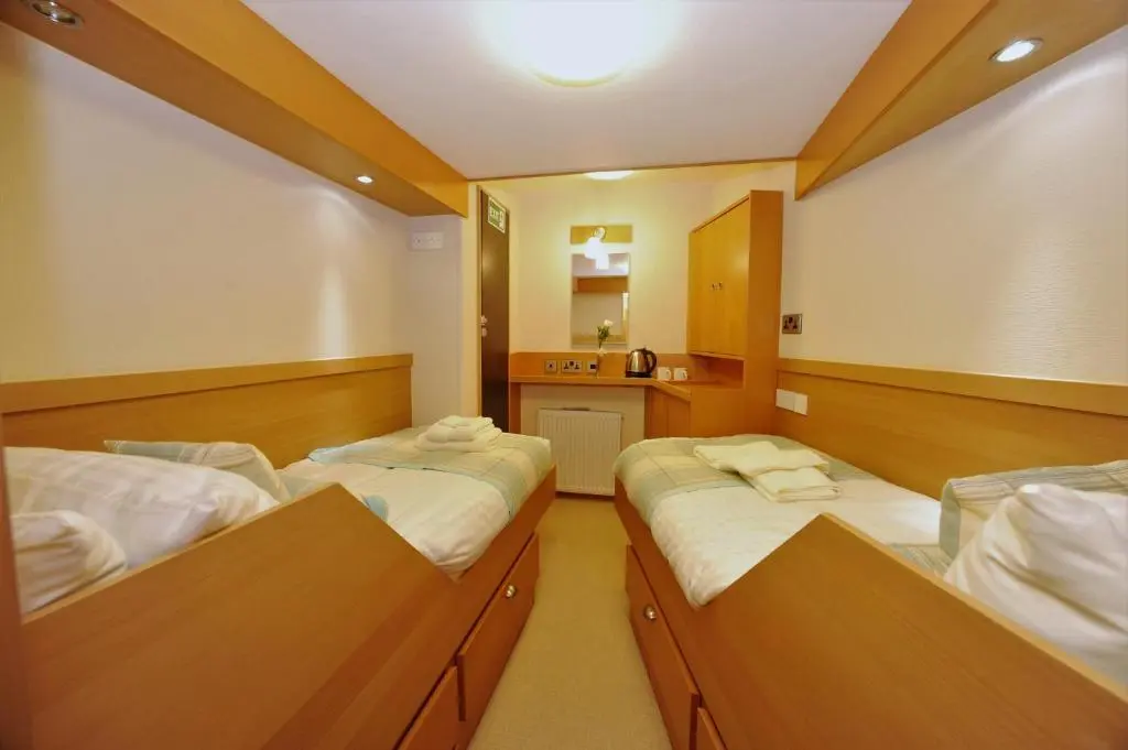 a room with two beds and a small kitchen at The Boat and Breakfast in Inverness
