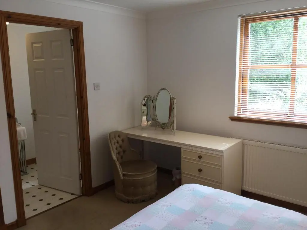 a bedroom with a dressing table and a mirror at Two-Bedroom Apartment - Golf View Free Parking in Inverness
