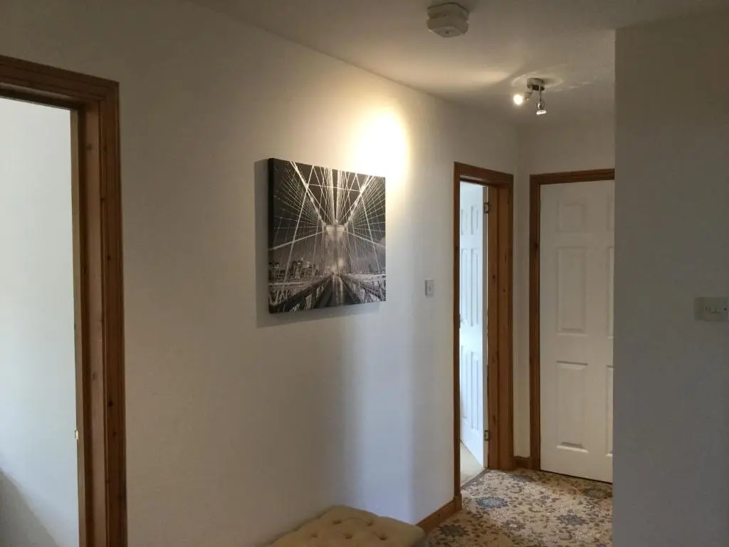 a hallway with a picture on the wall and a door at Two-Bedroom Apartment - Golf View Free Parking in Inverness
