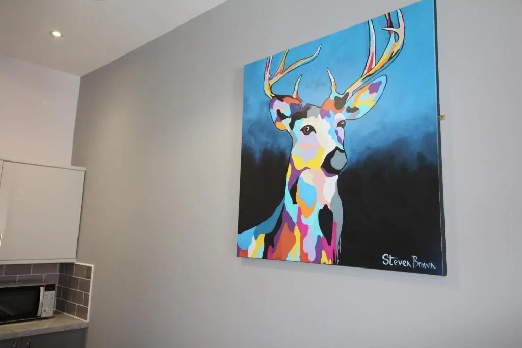 a painting of a deer hanging on a wall at Douglas House Apartments in Nairn