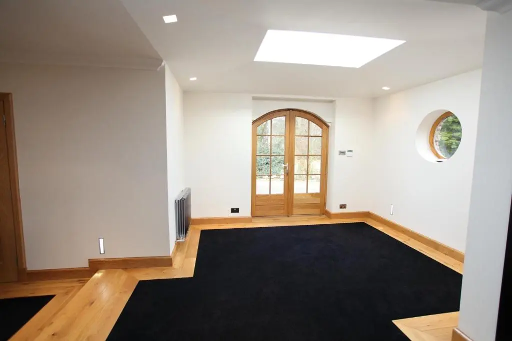 an empty room with a door and a black rug at Craig Alvah Lodge in Banff