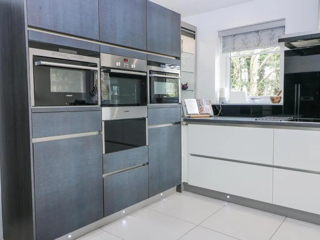 a kitchen with gray and white cabinets and appliances at P'lace of Glassaugh in Banff