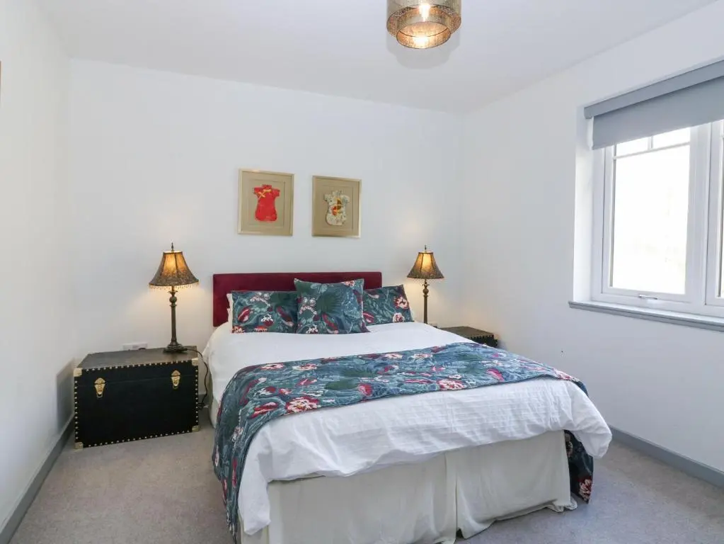 a bedroom with a bed and two lamps and a window at P'lace of Glassaugh in Banff