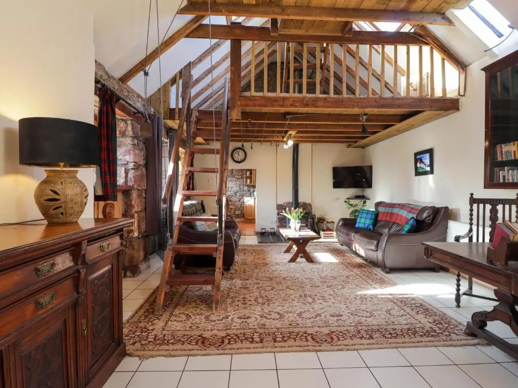a living room with a loft with wooden ceilings at Milltown House in Turriff