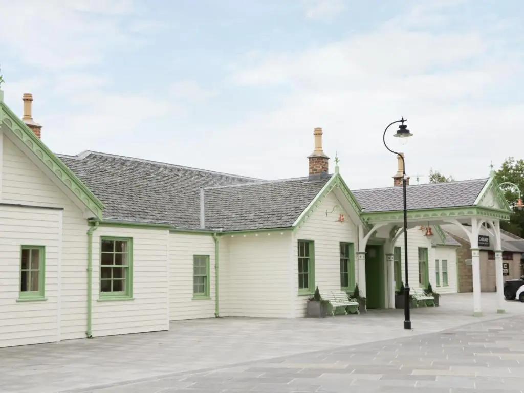 a white house with green trim and a street light at Westwood in Ballater