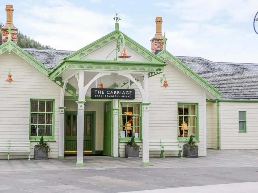 a white building with a sign that reads the challenge inheritance at Westwood in Ballater