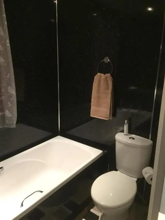 a bathroom with a white toilet and a bath tub at The Cottage Aberlour in Aberlour