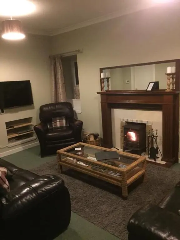 a living room with a coffee table and a fireplace at The Cottage Aberlour in Aberlour