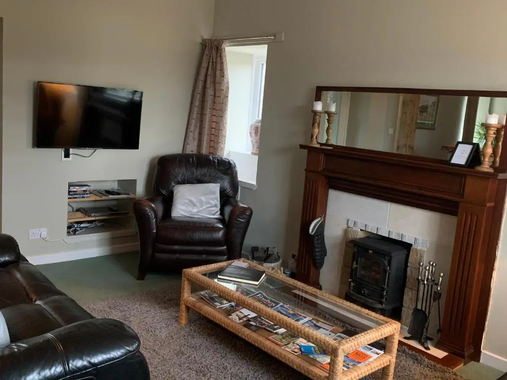 a living room with a couch and a fireplace at The Cottage Aberlour in Aberlour