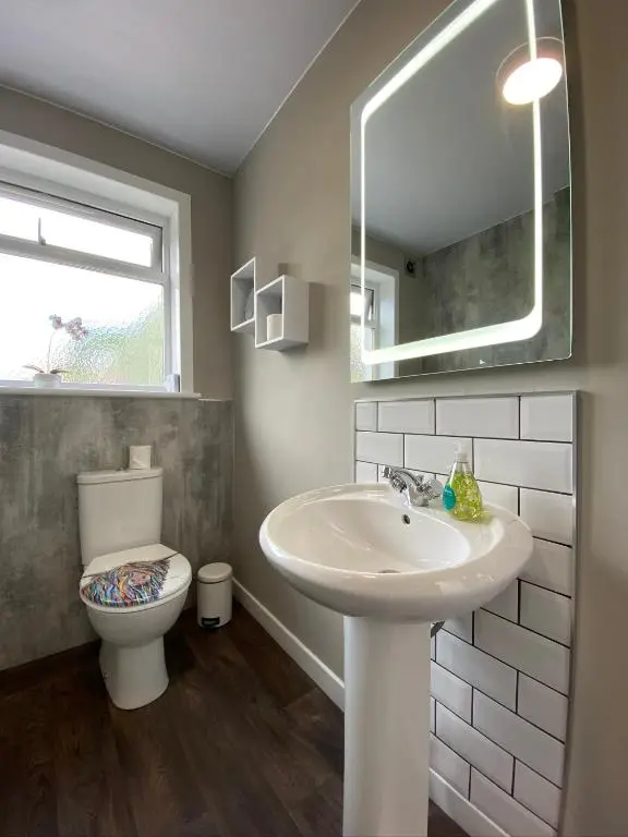 a bathroom with a sink and a toilet and a mirror at Wells Street Cottages No 26 By The River Ness in Inverness