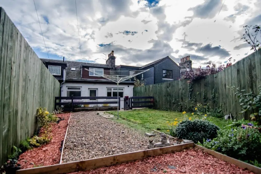 a backyard with a fence and a garden at Wells Street Cottages No 26 By The River Ness in Inverness
