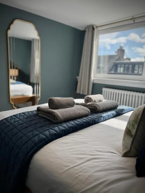 a bed with towels on it in a bedroom at Wells Street Cottages No 26 By The River Ness in Inverness