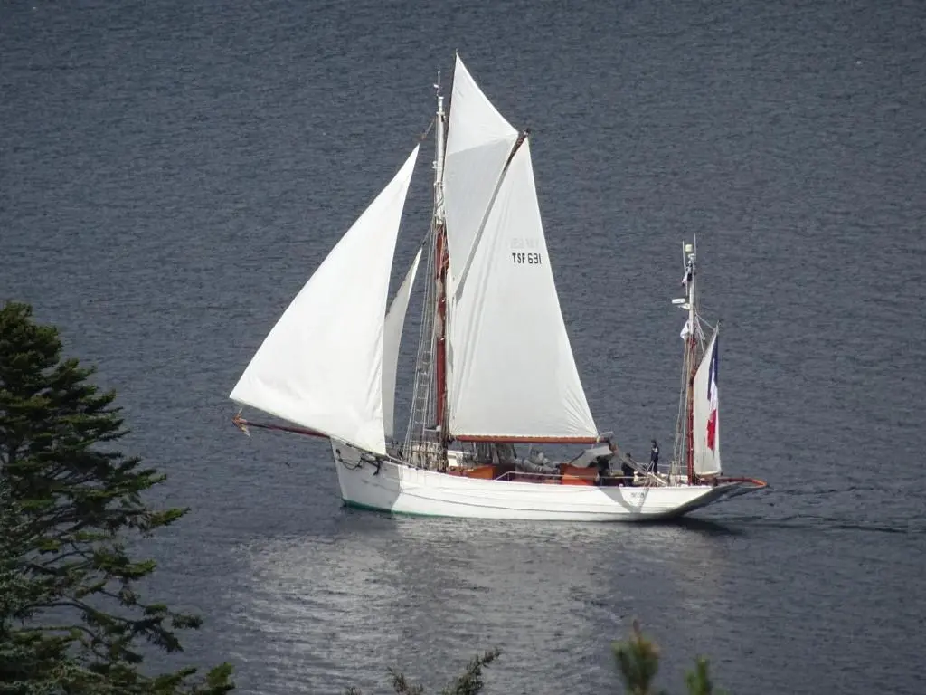 a sailboat with white sails in the water at The Loft at Log Ness in Foyers
