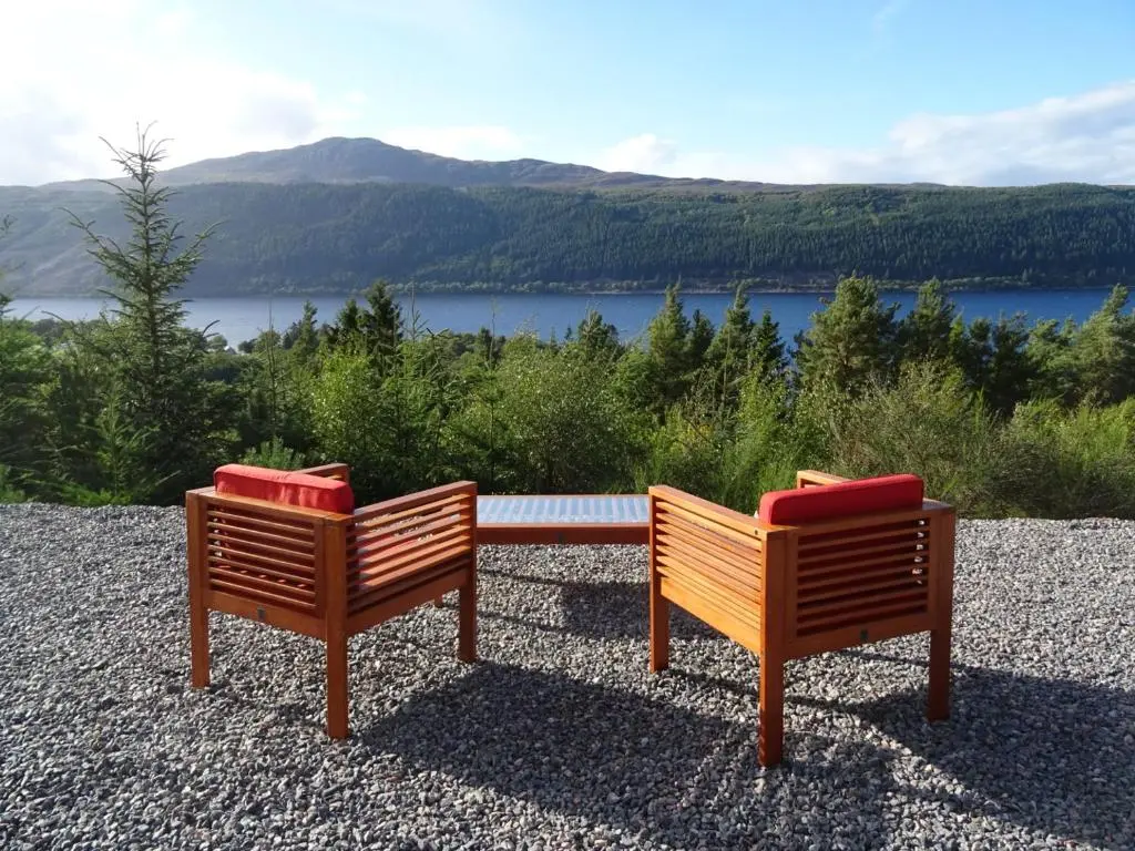 two wooden benches sitting on top of a hill at The Loft at Log Ness in Foyers