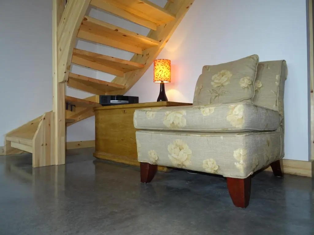 a chair in a room with a lamp on a desk at The Loft at Log Ness in Foyers