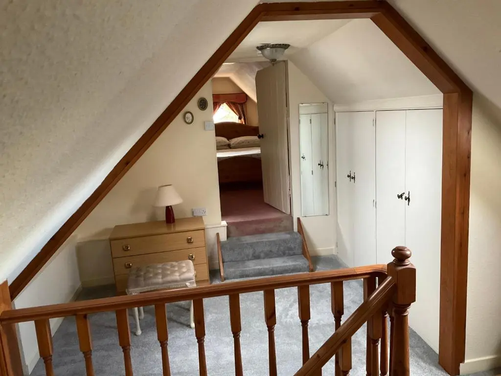 an attic room with a staircase and a bedroom at Three-Bedroom Old Cottage Free Parking in Inverness