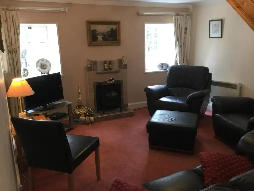 a living room with a couch and a chair and a television at Three-Bedroom Old Cottage Free Parking in Inverness