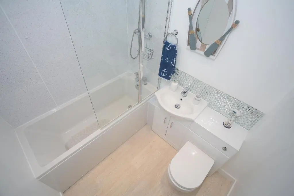a bathroom with a toilet and a sink and a shower at Seaesta Apartments in Macduff