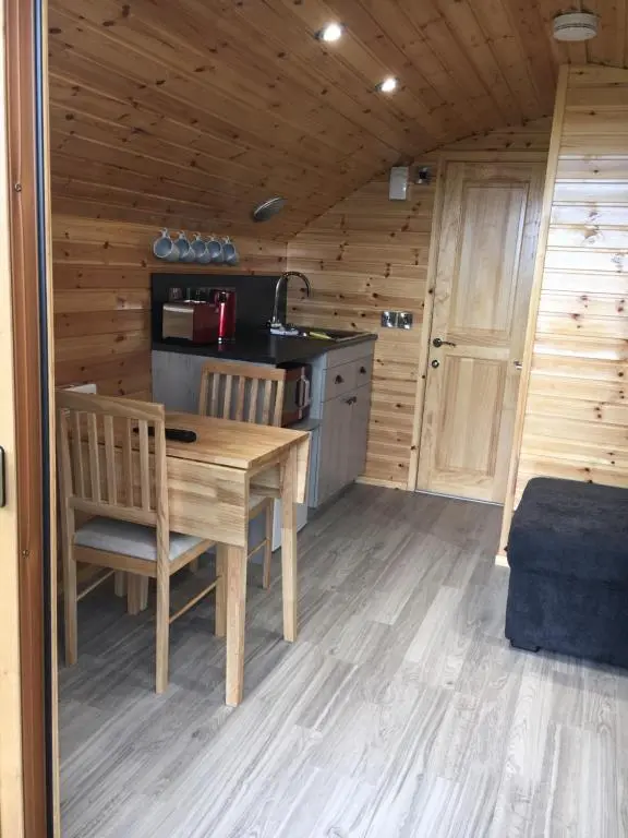 a kitchen with a table and chairs in a cabin at Greencraig Pods in Buckie