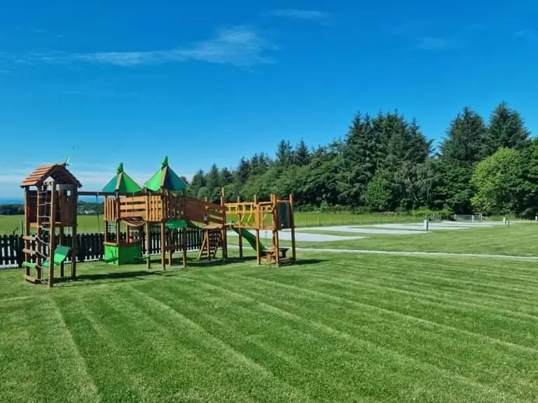 a playground in a grassy field with a park at Greencraig Pods in Buckie