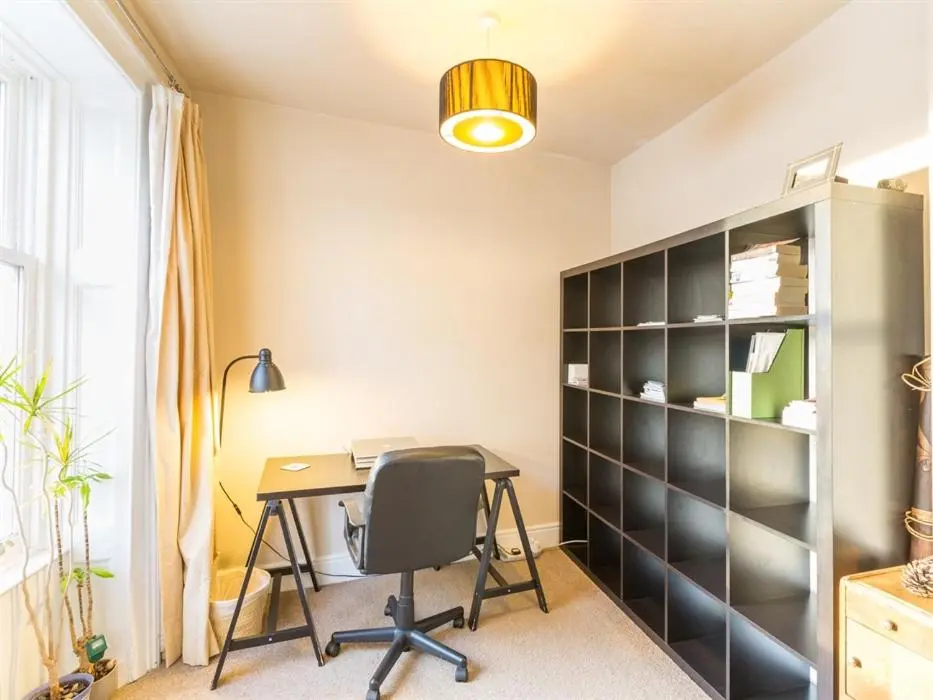 an office with a desk and a book shelf at River Cottage in Inverness