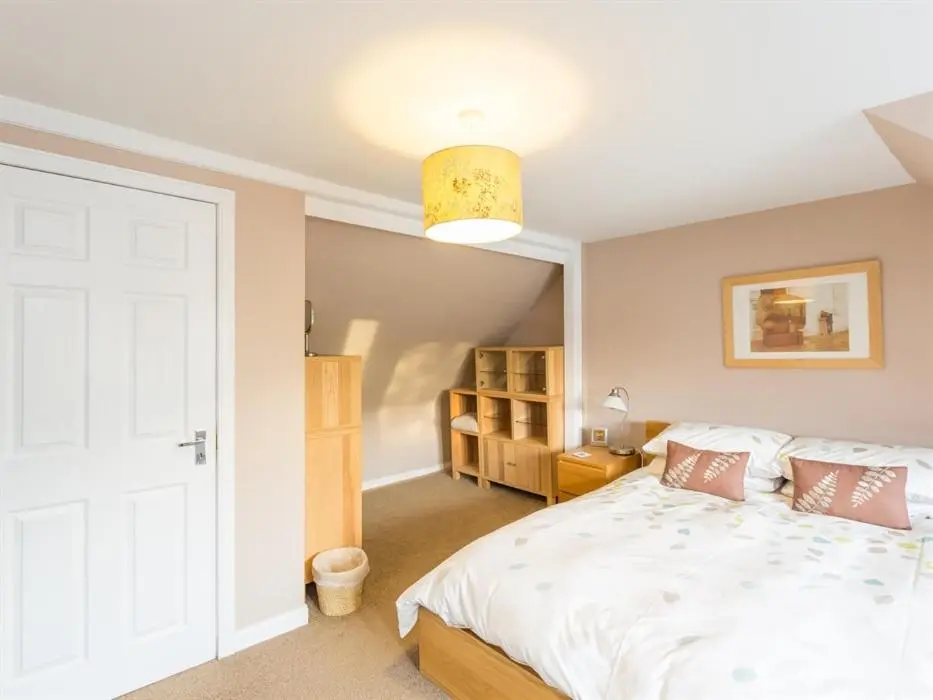 a bedroom with a white bed and a light at River Cottage in Inverness